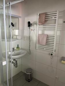 La salle de bains blanche est pourvue d'un lavabo et d'une douche. dans l'établissement Pension Steiner, Matrei am Brenner 18b, 6143 Matrei am Brenner, à Mühlbachl