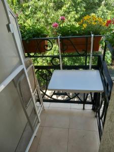 a white bench sitting on a balcony with flowers at Three Dolphins Family Hotel in Varna City