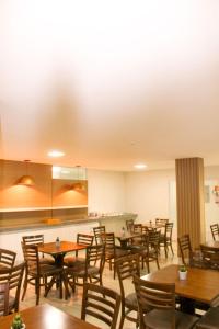 a dining room with wooden tables and chairs at Hotel Rochedo AL in Penedo