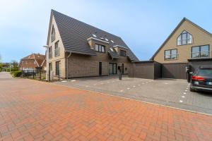 a house with a brick driveway in front of it at Ragnar Maisonette in Büsum