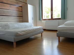 ein Schlafzimmer mit zwei Betten und einer Holzwand in der Unterkunft Appartement duplex avec cour 10 pers in Berck-sur-Mer