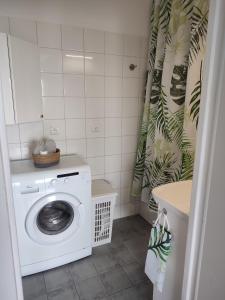 a white washing machine in a bathroom with a shower curtain at Chill Studio in Łódź