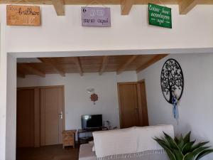 a living room with a white couch and signs on the wall at Lar Dos Guerreiros in Vila Nova de Milfontes