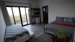 a bedroom with a bed and a large window at Casa do Sol in Diamantina