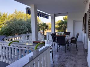 a patio with a table and chairs on a balcony at Apartments Lora in Vir
