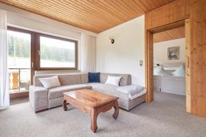 uma sala de estar com um sofá e uma mesa de centro em Landhotel Fuchs em Eisenbach
