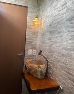 uma casa de banho com um lavatório de pedra sobre uma mesa de madeira em Casa Bela Vista em Piranhas