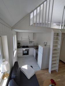 a small kitchen with a staircase in a tiny house at Guesthouse with terrace in Arendal