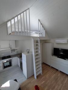 a white kitchen with a staircase in a room at Guesthouse with terrace in Arendal