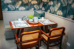 a table with two chairs and a table with plates and cups at 503 One Pontefino Towers in Batangas City