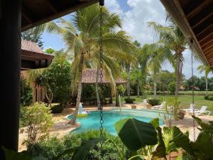 a swimming pool with a swing in a yard at 5-Bedroom Villa with Private Pool, Maid and Golf Course Views at Casa de Campo Resort in La Romana