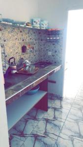 a kitchen with a sink and a stone wall at Villa Saiid in Moulay Bousselham