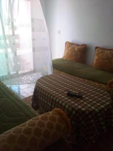 a living room with two beds and a window at Villa Saiid in Moulay Bousselham