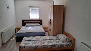 Habitación pequeña con 2 camas y armario en Apartman Natasa, en Foča