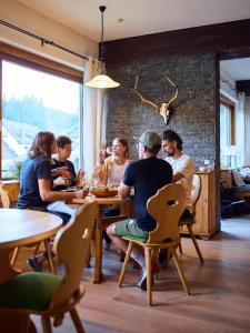 Landhotel Fuchs في إيسينباخ: مجموعة من الناس يجلسون على الطاولات في المطعم