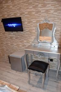 a desk with a chair and a tv on a wall at Ghazalle Oasis Hotel 1 in El Biar