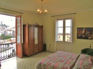 Schlafzimmer mit einem Bett, einem Schrank und Fenstern in der Unterkunft Hotel Alhambra in La Orotava