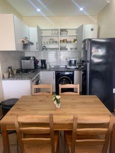 a kitchen with a wooden table and a black refrigerator at Cosy Appartement with sea view in Plage de Mehdia