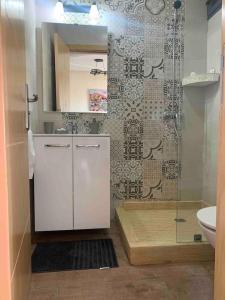 a bathroom with a shower and a sink and a toilet at Cosy Appartement with sea view in Plage de Mehdia