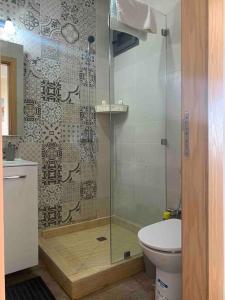 a bathroom with a glass shower with a toilet at Cosy Appartement with sea view in Plage de Mehdia