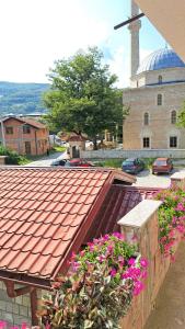 una casa con techo rojo y algunas flores en Apartman Natasa, en Foča