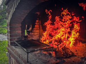 een bakstenen oven met een vuur erin bij Tronoska Oaza Korenita, Loznica in Loznica