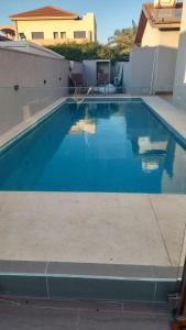 una piscina con acqua blu in una casa di פינה בשחף a Bustan HaGalil