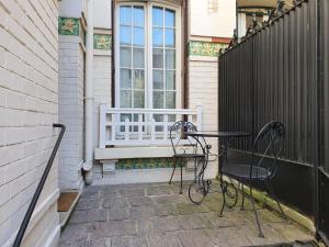 un tavolo e sedie su un portico con finestra di 2 chambres dans une maison proche de Paris et du Stade de France a Enghien-les-Bains