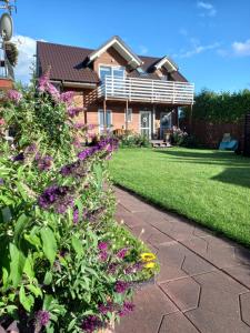 a garden with purple flowers in front of a house at Morski 1 in Stegna