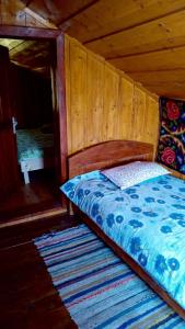 a bed in a wooden room with a wooden wall at Nu mai este valabil decat telefonic in Lunca Ilvei