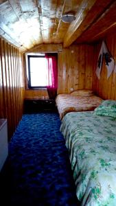 a bedroom with two beds in a wooden cabin at Nu mai este valabil decat telefonic in Lunca Ilvei