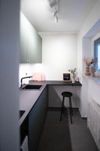 a kitchen with a sink and a stool in it at Stylisches Design-Apartment in Bad Tölz