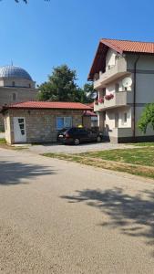 un coche está estacionado frente a un edificio en Apartman Natasa, en Foča