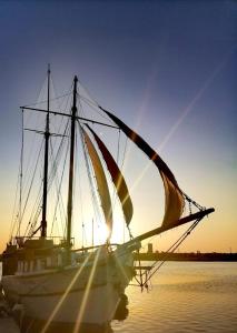 a sail boat in the water with the sun setting at Corabia Santa Marina in Sulina