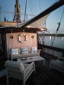 a boat with a couch and two chairs on it at Corabia Santa Marina in Sulina