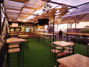 阿里卡Hostel Willka Kuti Backpackers的一间摆着桌椅的餐厅，背景中站着一名男子