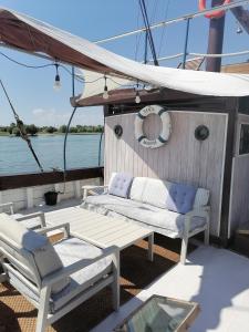 a boat with two chairs and a table on the deck at Corabia Santa Marina in Sulina