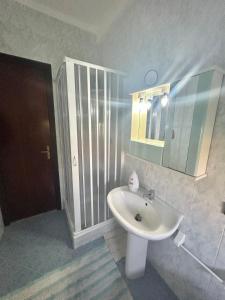 łazienka z białą umywalką i lustrem w obiekcie Aromi di Sicilia Casa Vacanze w mieście Palermo
