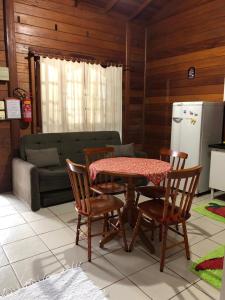 eine Küche mit Tisch und Stühlen und einer Couch in der Unterkunft Residencial Alvorada in Bombinhas