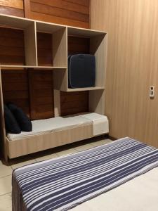 ein Schlafzimmer mit einem Bett und einem Fernseher in einem Zimmer in der Unterkunft Residencial Alvorada in Bombinhas