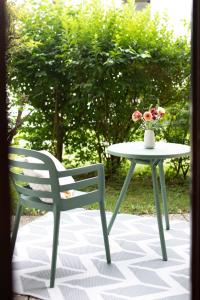 una mesa y una silla y una mesa con un jarrón de flores en Stylisches Design-Apartment, en Bad Tölz