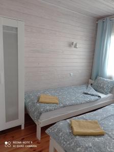 2 camas individuales en una habitación con pared en Strefa Kampinos, en Brochów