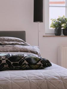 a bed with a blanket on it with a window at Cozy Apartment in historical Alt-Lobeda near Uni-Klinik Jena in Jena