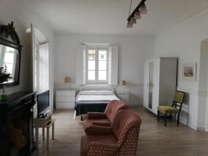 a bedroom with a bed and a couch and a chair at Apartamentos Turísticos La Solana in Colombres