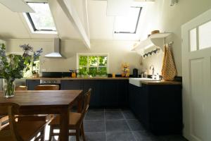 a kitchen with a wooden table and a dining room at Het Betuws Erfje in Maurik +12 photos