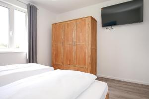 1 Schlafzimmer mit 2 Betten und einem TV an der Wand in der Unterkunft Weiße Villen Wohnung 19 in Boltenhagen