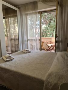 ein Schlafzimmer mit einem großen Bett und einem großen Fenster in der Unterkunft Camere al Mare in Lido di Camaiore