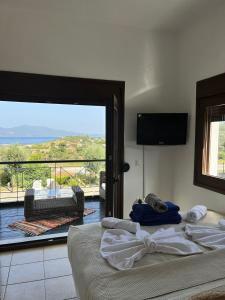 a bedroom with a bed and a balcony with a view at Melro in Skiathos