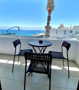 een tafel en stoelen op een balkon met uitzicht op de oceaan bij Sea La Vie #1 - Luxury Seaview apartment in Paphos City