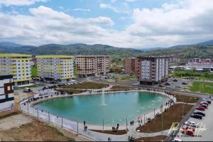 una gran piscina de agua en una ciudad con edificios en Athena Apartman, en Lukavica